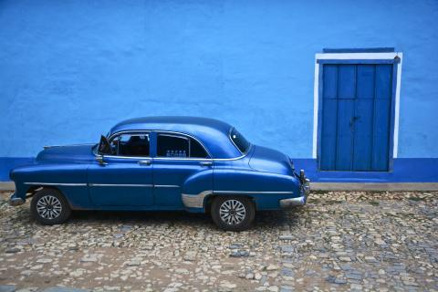 Classic car, blue against blue wall, in Cuba